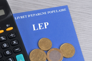 Livret d'épargne populaire associé à une calculatriceet des pièces de monnaie