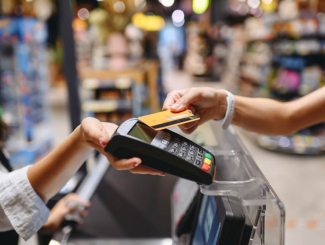 Femme qui règle ses achats dans un supermarché avec sa carte de paiement sans contact
