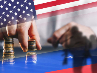 une main soulève une pile de pièces sur fond de drapeau des états-unis