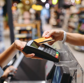 Femme qui règle ses achats dans un supermarché avec sa carte de paiement sans contact