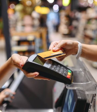 Femme qui règle ses achats dans un supermarché avec sa carte de paiement sans contact