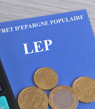 Livret d'épargne populaire associé à une calculatriceet des pièces de monnaie