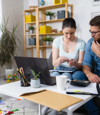 couple faisant ses comptes devant un ordinateur portable