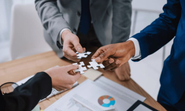 trois mains tenant chacune une pièce de puzzle