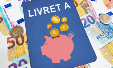 Image d'illustration représentant un livret A de couleur bleue sur lequel est dessiné une tirelire dans laquelle tombent des pièces en euros. L'arrière plan de l'image est constitué de billets et pièces en euros.
